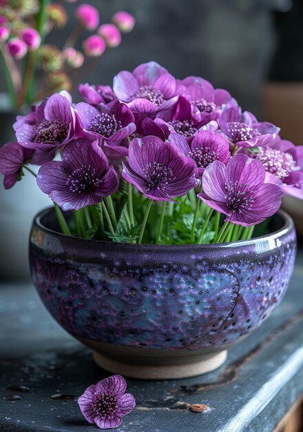 Purple anemones in ceramic bowl on wooden table