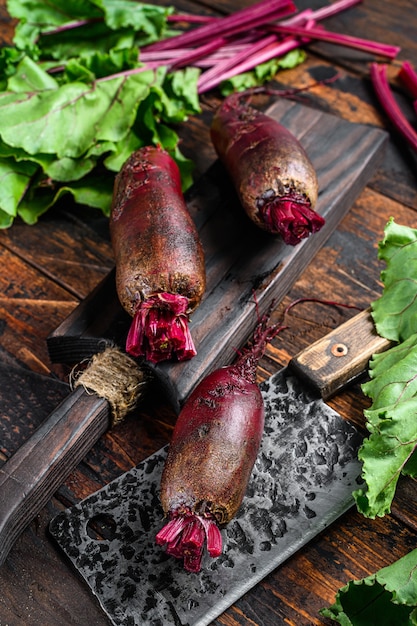 Purple beet on a cutting board. Dark wooden background. Top view.