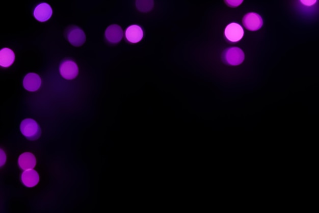 Фиолетовые огни боке на черном фоне