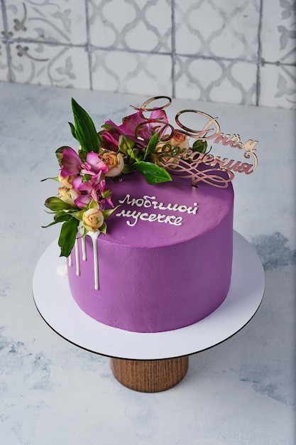 Purple cake for a girl decorated with real flowers Translation quotBeloved mother Happy birthdayquot