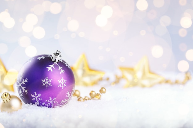 Purple Christmas ball with decoration on snow