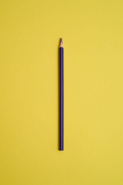 Purple colored pencil isolated on yellow table