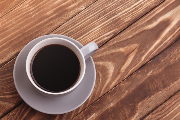 Purple cup of coffee with macaroons on the wooden background