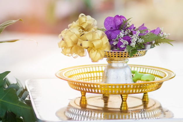 The purple flower and gold ribbon in the tray with pedestal. Celebration concepts.