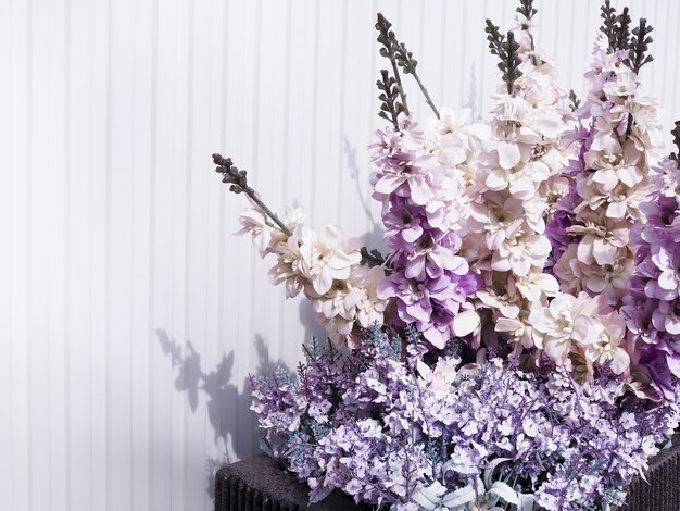 Purple flowers against white wooden wall