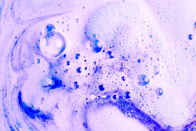 Schiuma viola dopo aver dissolto la bomba da bagno a colori in acqua