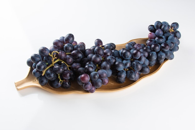 Purple fruit grape isolated on white surface.