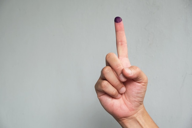 Photo purple ink applied on finger after pemilu or presidential election in indonesia