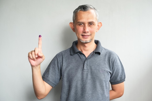 Photo purple ink applied on finger after pemilu or presidential election in indonesia