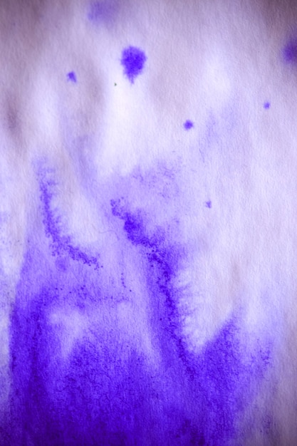 Purple ink stain on a sheet of white paper macro. Abstract background. Spreads ink stains with streaks on a white background. Absorb close-up