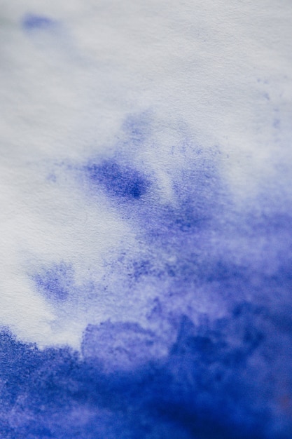 Photo purple ink stain on a sheet of white paper macro. abstract background. spreads ink stains with streaks on a white background