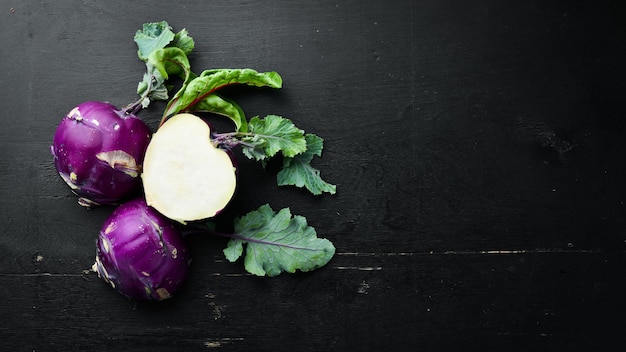 Purple kohlrabi cabbage On a black background Top view Free space for your text