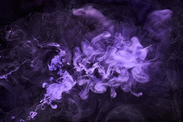 紫色のライラック色とりどりの煙の抽象的な背景のアクリル絵の具の水中爆発