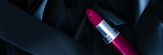 Purple lipstick on black silk background luxury makeup and beauty cosmetic