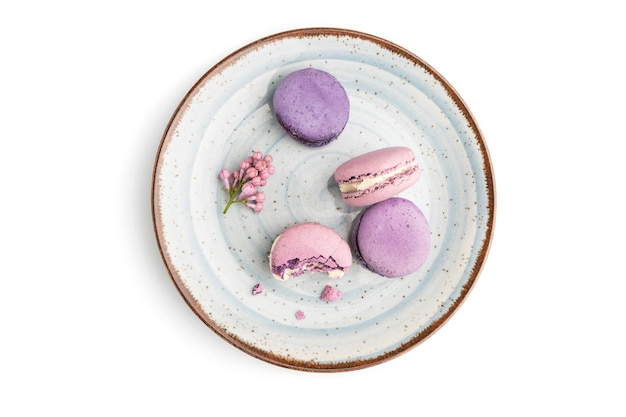 Purple macarons or macaroons cakes on blue plate isolated on white background. Top view, flat lay, close up.