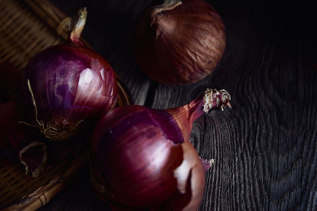 Purple onions in a basket on a wooden table