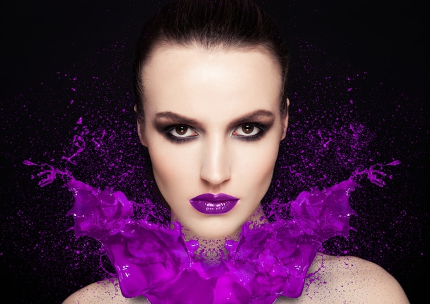 美容メイクモデルの女の子に紫の塗料スプラッシュ