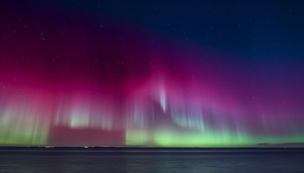 A purple and red aurora lights up the sky over lake superior.