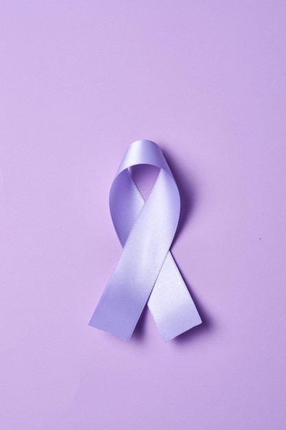 Фиолетовая лента всемирный день борьбы против рака 4 февраля на плоской фиолетовой поверхности