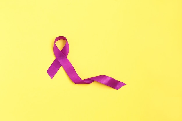 Foto nastro viola su sfondo giallo per il giorno del cancro