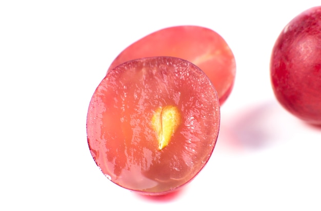 Purple ripe grapes cut in half on the white background. Close up photo. Ecological fruit for vegans. Vitamins.