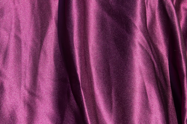 紫のサテンの背景。シルクの質感。生地パターン