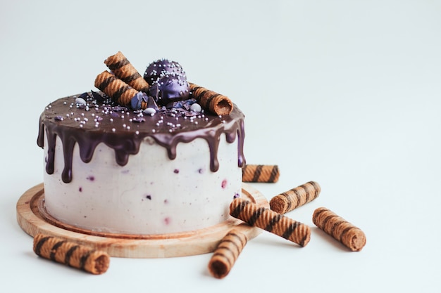 Purple schittert bosbessencake met chocoladeglans op een witte ruimte van het oppervlaktekopie