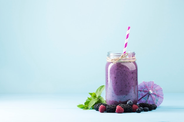 Photo purple smoothie jar on blue background