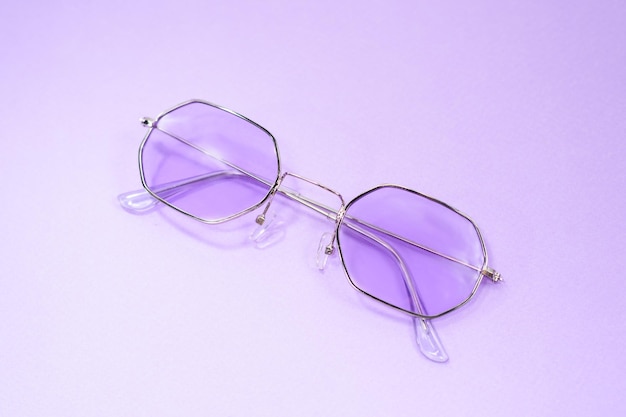 Purple sun glasses on the purple background