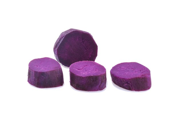 Purple sweet potatoes with slices isolated on white.