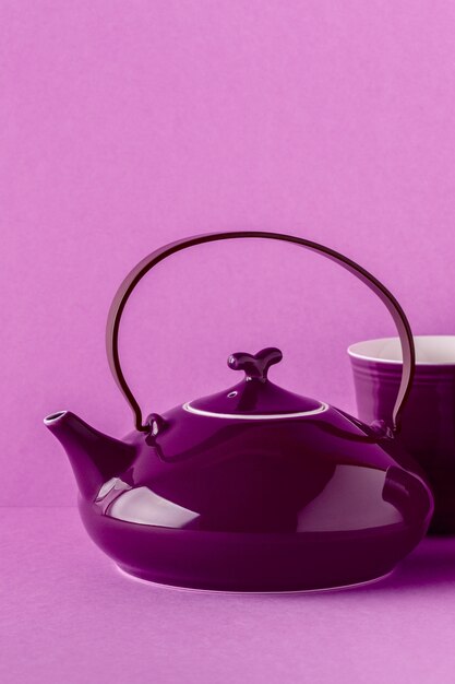 Purple teapot and cup on a lilac background