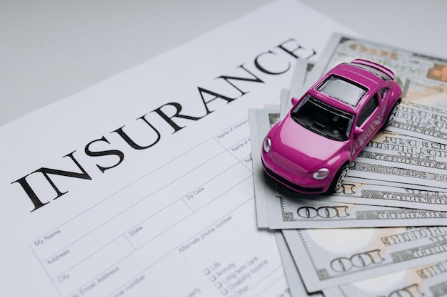 Purple toy car with money on an insurance contract closeup Benefits and safety concept