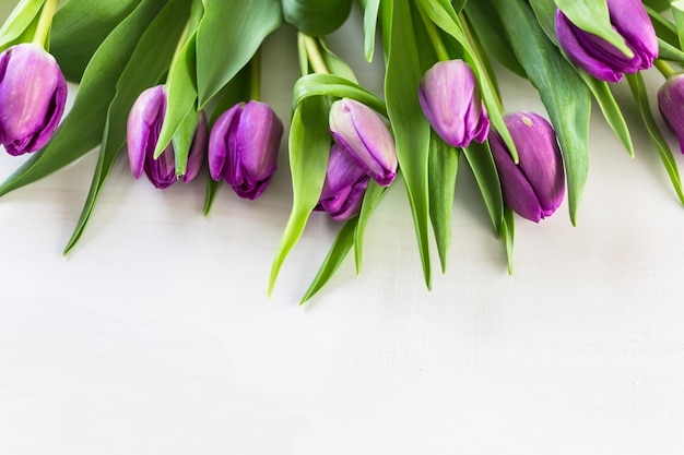 Фиолетовые тюльпаны на День матери на белой деревянной доске.