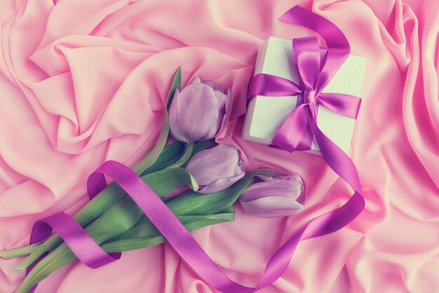 Фиолетовые тюльпаны на розовом текстильном фоне