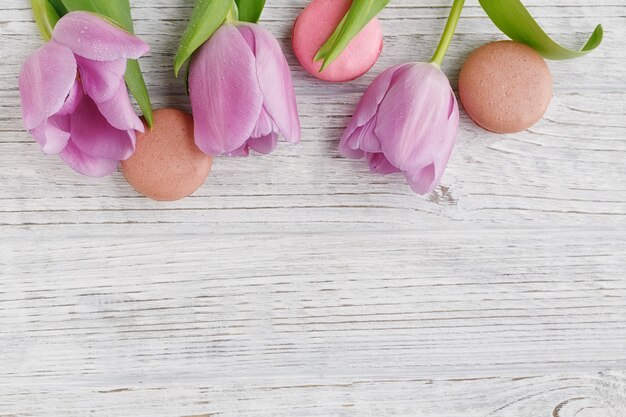 Purple tulips and sweet pastel french macaroons on wooden table