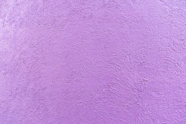 Purple - violet colour on the abstract random texture curve cement on the wall at afternoon time.