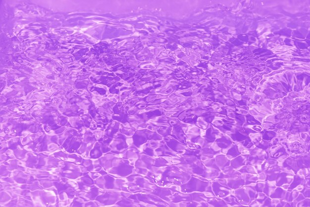 Purple water bubbles with ripples on the surface transparent pink colored clear calm water surface