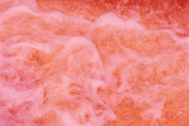 Foto bolle d'acqua viola con increspature sulla superficie superficie d'acqua limpida e calma di colore rosa trasparente