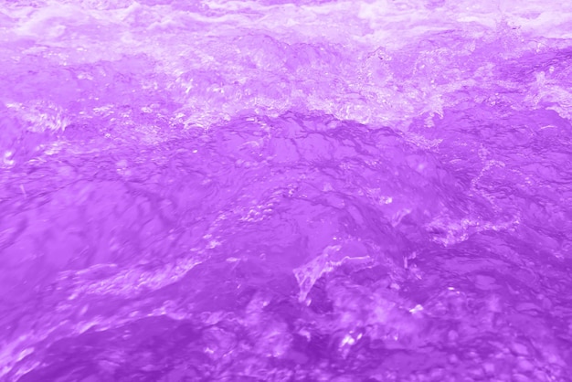表面に波紋のある紫色の水の焦点がぼやけて透明な青い色の澄んだ穏やかな水