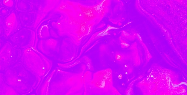 A purple and yellow background with a drop of liquid in the middle.