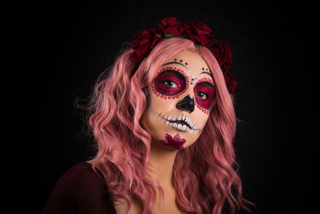 Purple, yellow, blue plastic balls.Woman with sugar skull makeup and pink hair isolated. Day of the dead.