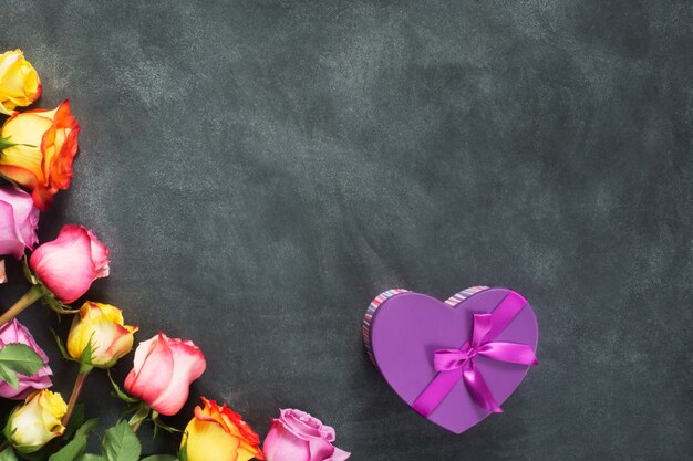 Purple and yellow roses, box present on black background