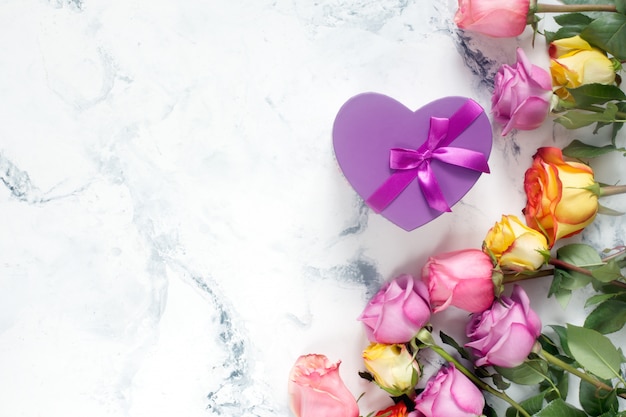 Purple and yellow roses, box present on white background