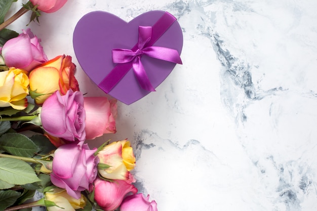 Purple and yellow roses, box present on white background