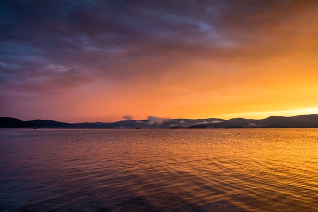 湖の紫黄色の夕日