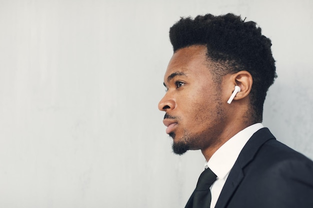 Purposeful black businessman in wireless earphones