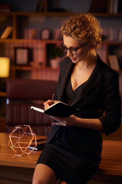 Foto imprenditore professionale giovane donna d'affari propositivo legge un libro donna d'affari in un bellissimo ufficio in luce cinematografica un bel ritratto