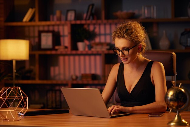 Photo purposeful young business woman professional entrepreneur works behind a laptop businesswoman in a b