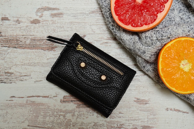 Purse, gray sweater and citrus fruits