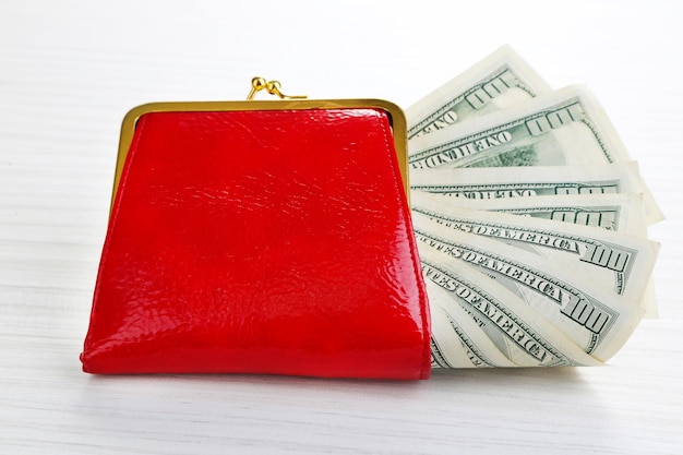 Purse with dollars banknotes on wooden table